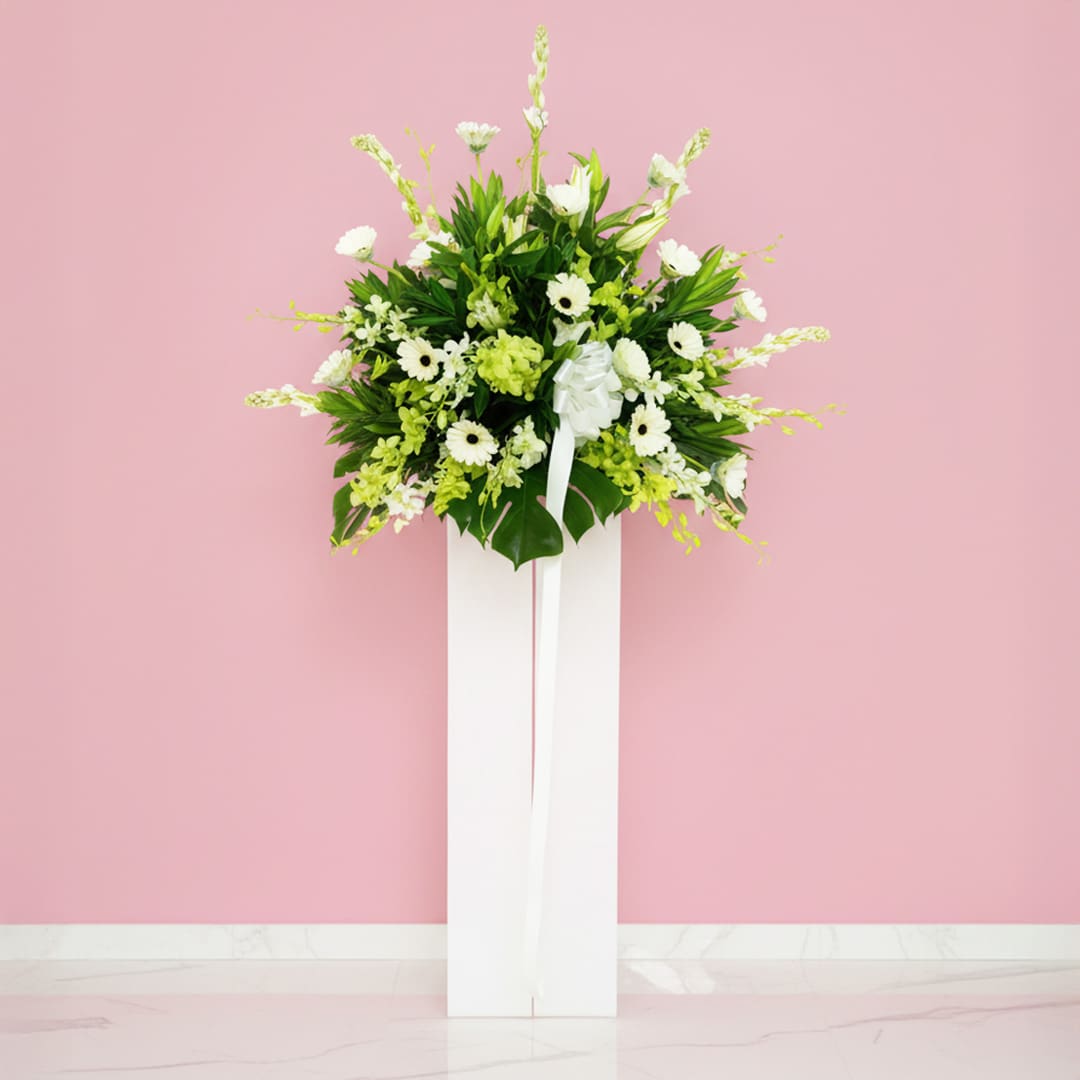 Bless the Soul A white stand displaying a delicate arrangement of white sympathy flowers, creating a serene and elegant atmosphere