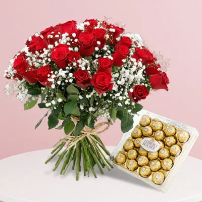 A bouquet of pink roses arranged in a paper bag alongside a piece of chocolate, creating a charming gift display.
