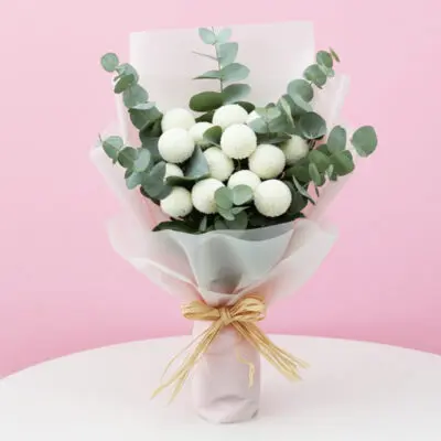 A hand bouquet featuring white flowers and eucalyptus leaves, elegantly arranged for a fresh and natural look.