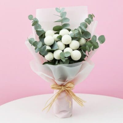 A hand bouquet featuring white flowers and eucalyptus leaves, elegantly arranged for a fresh and natural look.