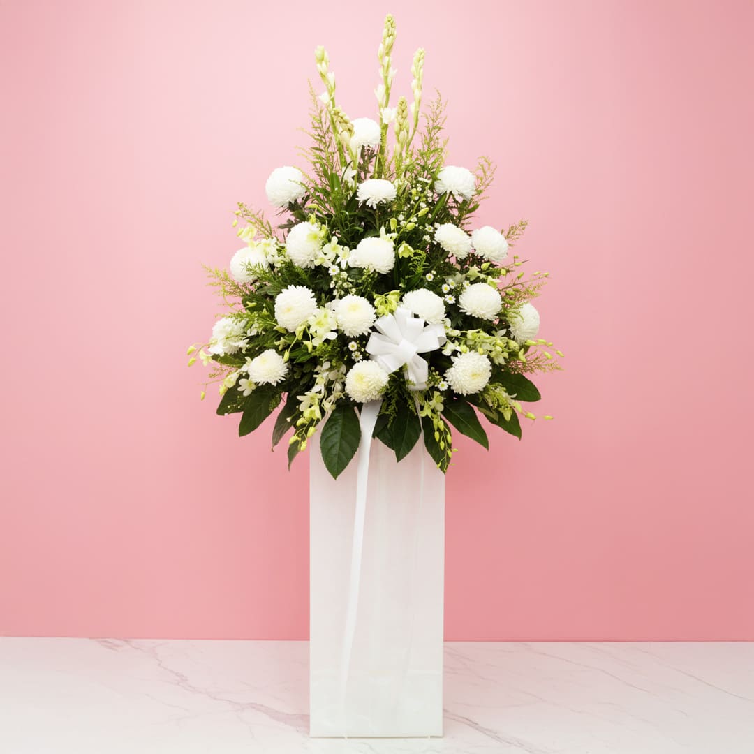 Condolences Flower Arrangement A white vase filled with white flowers and lush greenery, creating a serene and elegant floral sympathy arrangement