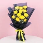 A bouquet of 12 vibrant yellow roses tied with a delicate yellow ribbon.