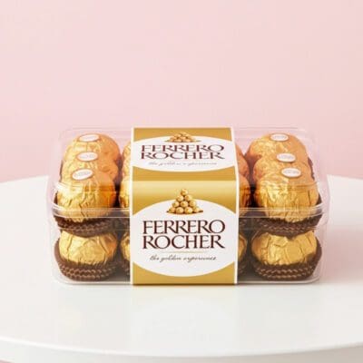 Ferrero Rocher chocolates displayed in a clear box, featuring their iconic gold foil and rich, layered design.