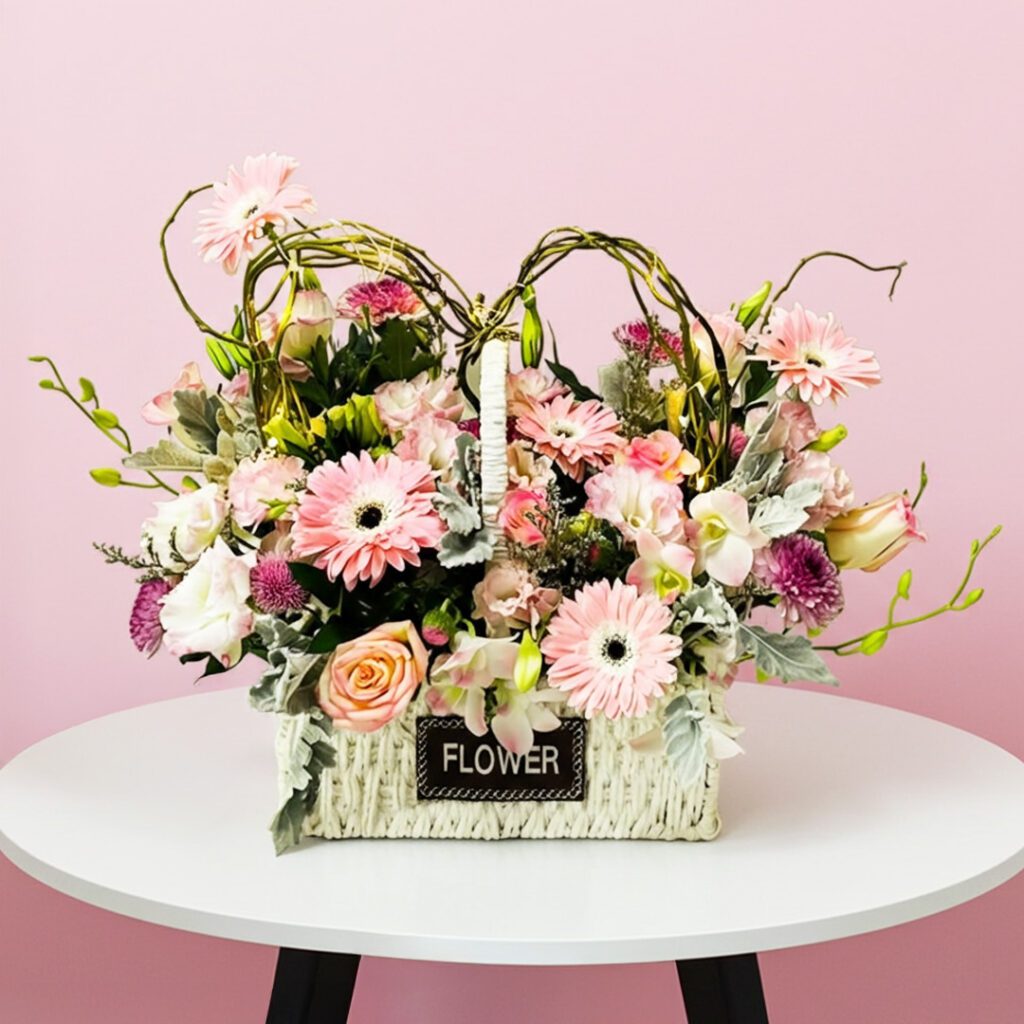 A basket filled with pink flowers placed on a wooden table, adding a touch of color to the setting.