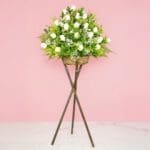 An arrangement of white roses on a stylish stand, showcasing their beauty.