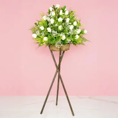 An arrangement of white roses on a stylish stand, showcasing their beauty.