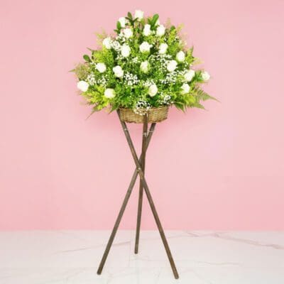 An arrangement of white roses on a stylish stand, showcasing their beauty.