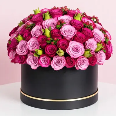 A large black box adorned with vibrant pink and purple roses, creating a striking floral contrast.
