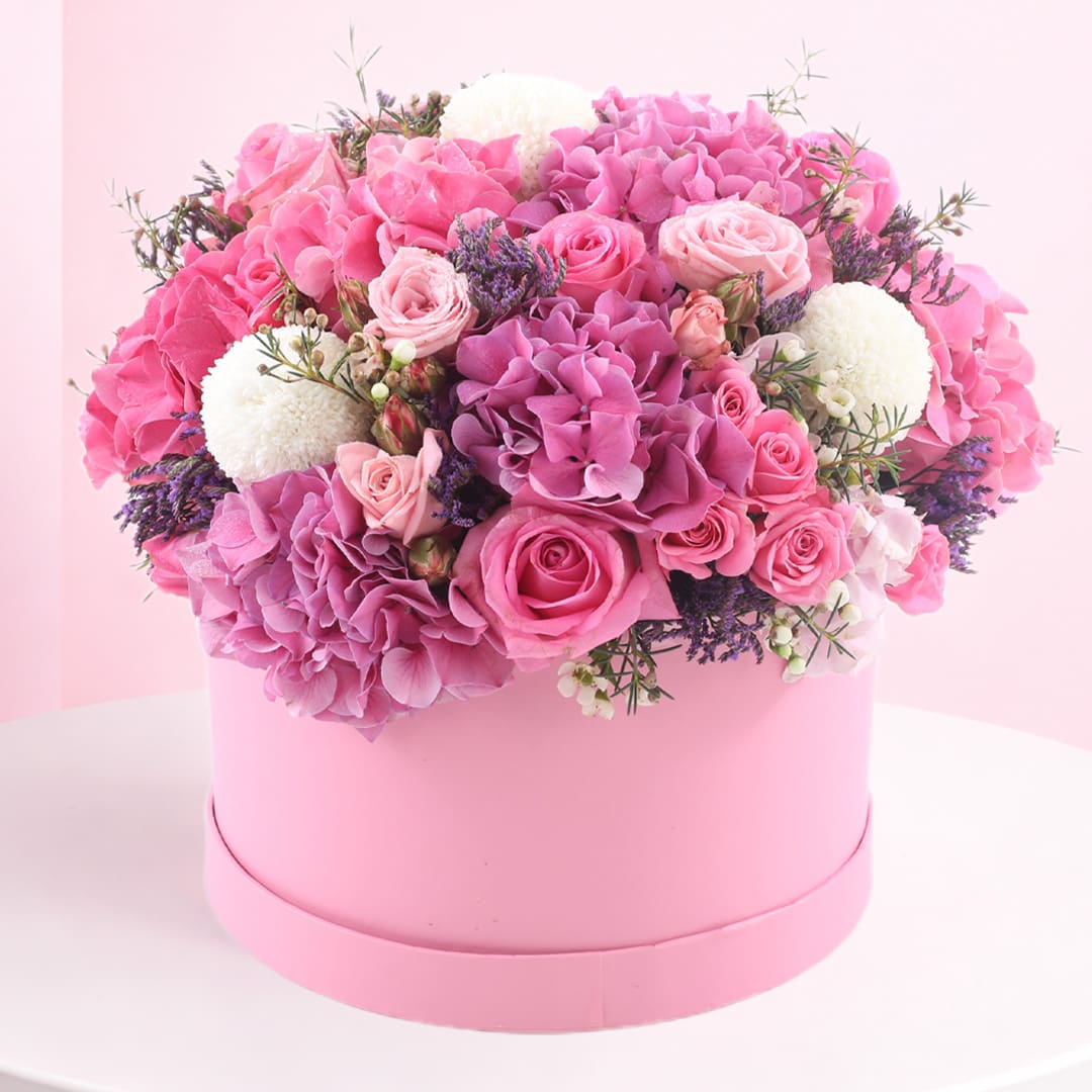 box-of-pink-lavish-flowers-2026 A pink box filled with an assortment of vibrant pink flowers, showcasing a lavish floral arrangement.
