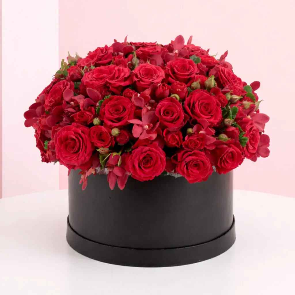 A large arrangement of red roses displayed in an elegant black box.