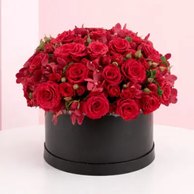 A large arrangement of red roses displayed in an elegant black box.