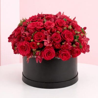 A large arrangement of red roses displayed in an elegant black box.