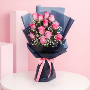 A bouquet of 12 pink roses surrounded by delicate baby's breath, elegantly arranged for a floral display.