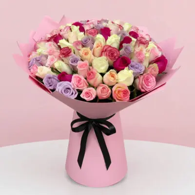 A vibrant pink bouquet featuring a mix of purple and pink roses arranged elegantly.
