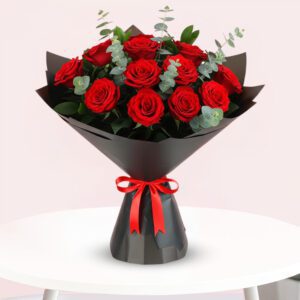 A bouquet of vibrant red roses tied with a matching red ribbon, elegantly arranged for a special occasion.