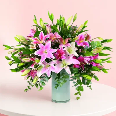 A vase filled with 20 stems of Stargazer Lilies, complemented by decorative fillers for an elegant floral arrangement.