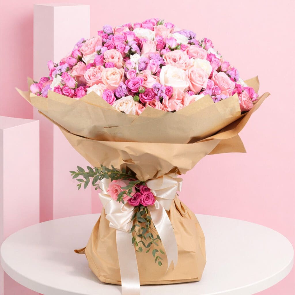 A bouquet of pink spray roses and purple roses arranged in a brown paper bag.