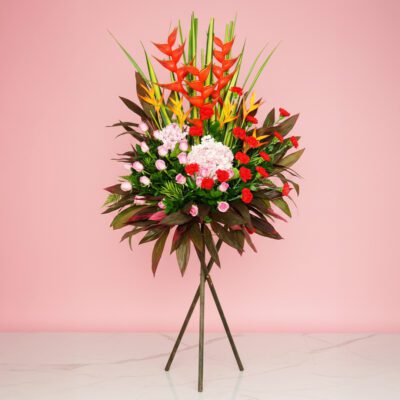 Assorted Flowers, Including Crab And Heliconia, On A Stand In Front Of A Vibrant Pink Wall.