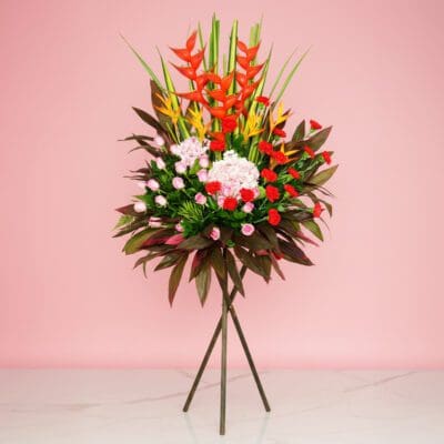 Assorted Flowers, Including Crab And Heliconia, On A Stand In Front Of A Vibrant Pink Wall.