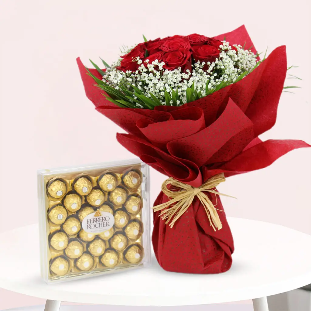 A vibrant bouquet of red roses accompanied by an assortment of chocolates, elegantly arranged for a romantic gift.