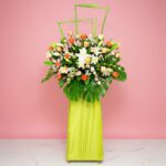 A Large Floral Arrangement Featuring 20 Roses, 5 Casa Lilies, 10 Eustomas, And Seasonal Greenery.