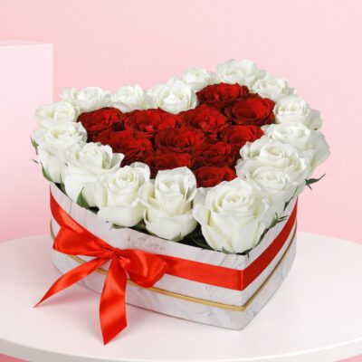 A heart-shaped box filled with vibrant red roses, symbolizing love and affection.