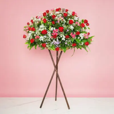 A Grand Opening Display Featuring A Large Arrangement Of Red Roses, Rose Sprays, And Seasonal Greenery On A Stand.