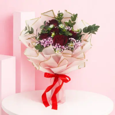 A bouquet of 13 vibrant red roses, elegantly arranged to create a stunning Crimson Blush display.