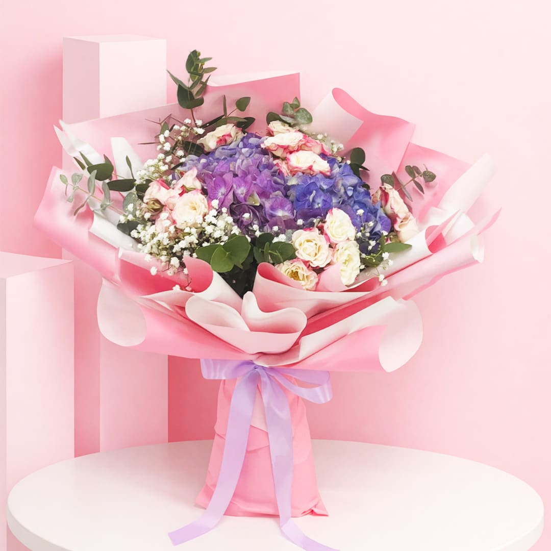 gorgeous-graces-2026 Hand bouquet composed of 2 hydrangeas and 8 spray roses in various colors, embodying peace and the essence of nature.