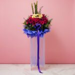 A majestic floral arrangement in a pink background, designed to impress at grand openings and celebrations.