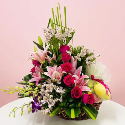 A basket filled with pink and purple flowers sits elegantly on a table.