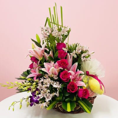 A basket filled with pink and purple flowers sits elegantly on a table.