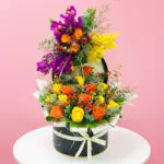 A vibrant assortment of flowers arranged in a sleek black box, showcasing a variety of colors and textures.
