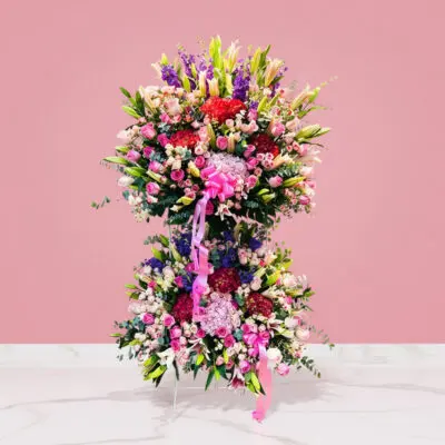 A large floral arrangement in a pink room, celebrating the majestic grand opening with vibrant colors and elegant blooms.