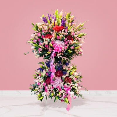 A large floral arrangement in a pink room, celebrating the majestic grand opening with vibrant colors and elegant blooms.
