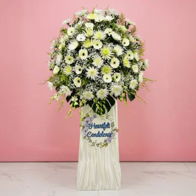 A decorative arrangement in white flowers, showcasing a sign that says Heartfelt Condolence.
