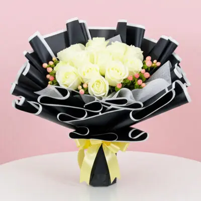 A bouquet of white roses tied with a yellow ribbon, elegantly arranged for a special occasion.