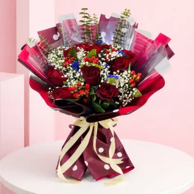 A stunning hand bouquet of 10 red cherry roses accented with baby breath, representing love and affection.