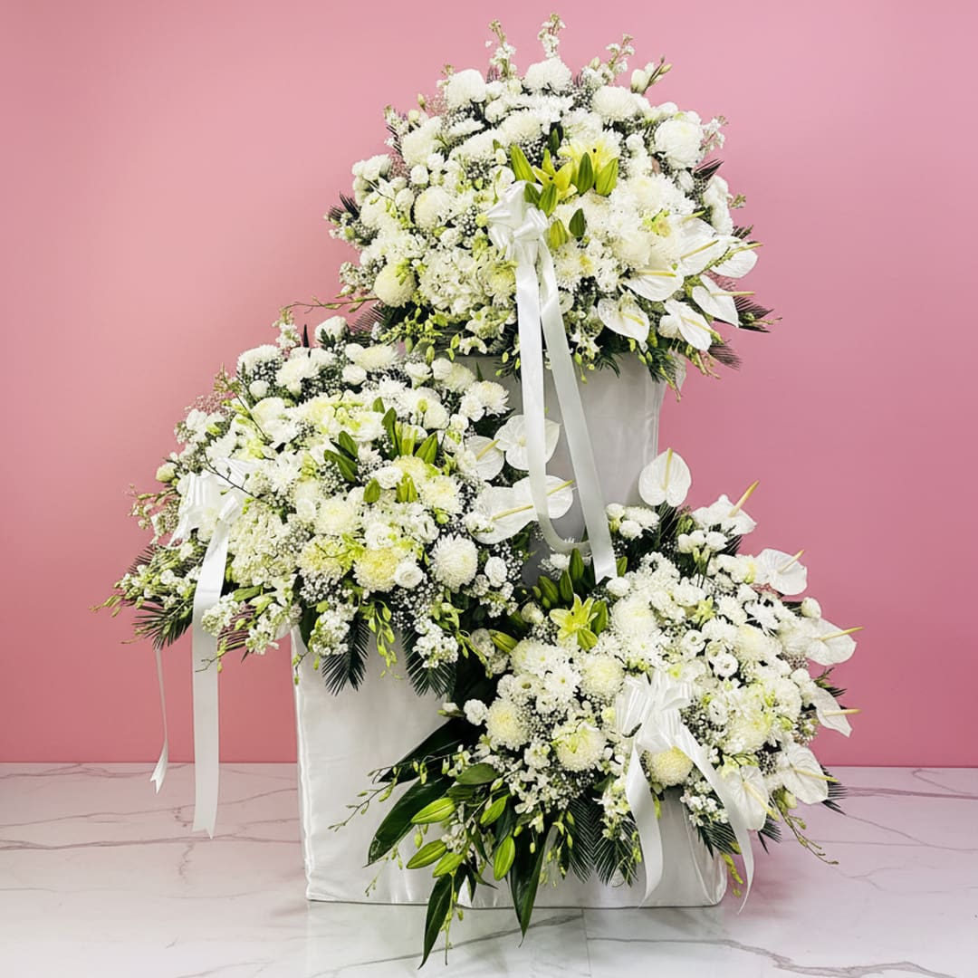 Graceful White Tribute An arrangement of white flowers prominently displayed on a pastel pink background, highlighting their beauty and freshness.