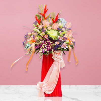 A lively floral arrangement in a vase on a pink wall, bursting with colors that convey hope and the spirit of fresh starts.