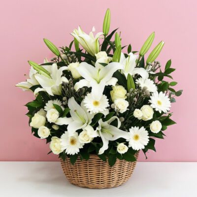 A basket filled with white flowers condolence set against a soft pink background.
