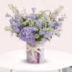 A purple and white vase filled with delicate lavender flowers, showcasing a serene and elegant floral arrangement.