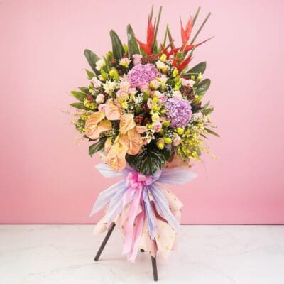 A vibrant bouquet of flowers on a stand against a pink wall, symbolizing success and elegance in any space.