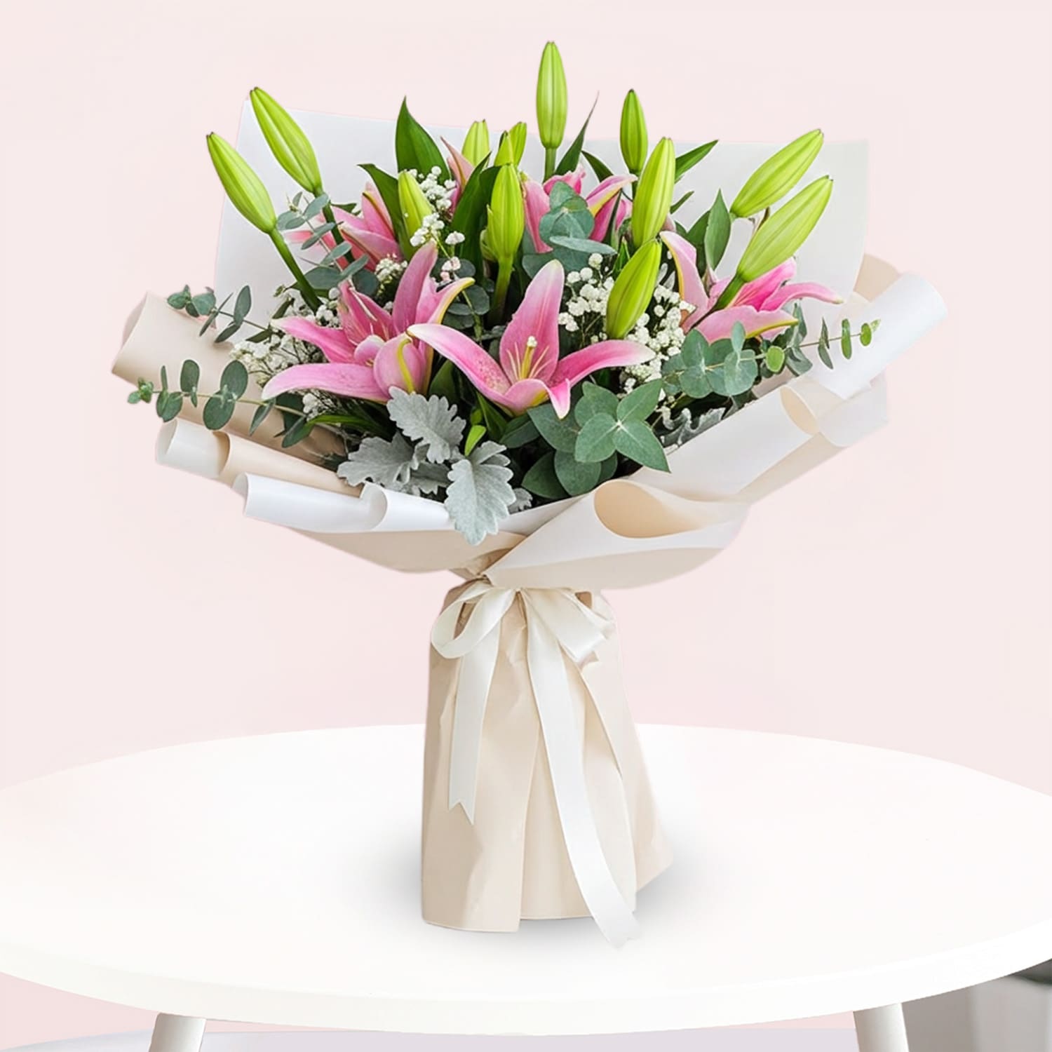 Melodies of Lilies-01-25 A vibrant bouquet featuring pink lilies surrounded by fresh eucalyptus leaves.