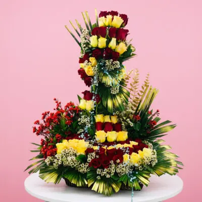 A large, colorful arrangement of flowers displayed on a table, showcasing various blooms and greenery.