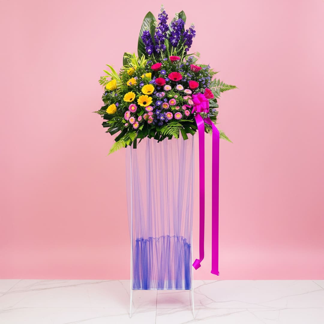 Grand Elegant Opening Stand-8901 A grand opening stand vase filled with assorted flowers, including Gerbera and Matthiola, against a pink background.