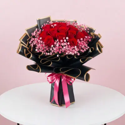 A vibrant bouquet featuring red roses and delicate pink flowers arranged together.