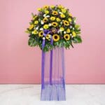 A Vibrant Display Of Sunflowers And Purple Flowers, Celebrating Joy At A Grand Opening Event.