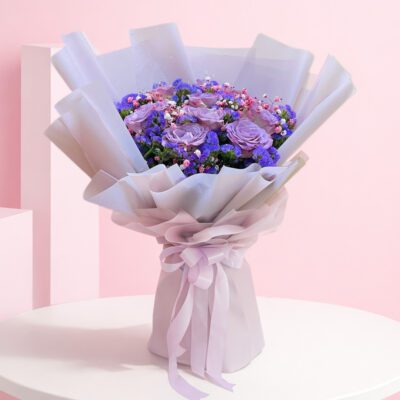 A bouquet featuring vibrant purple roses alongside delicate blue flowers, arranged elegantly.
