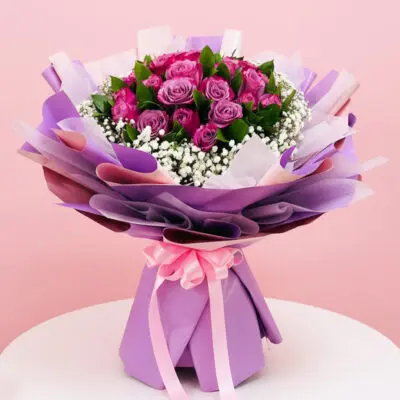 A bouquet featuring vibrant purple roses surrounded by delicate white baby's breath flowers.